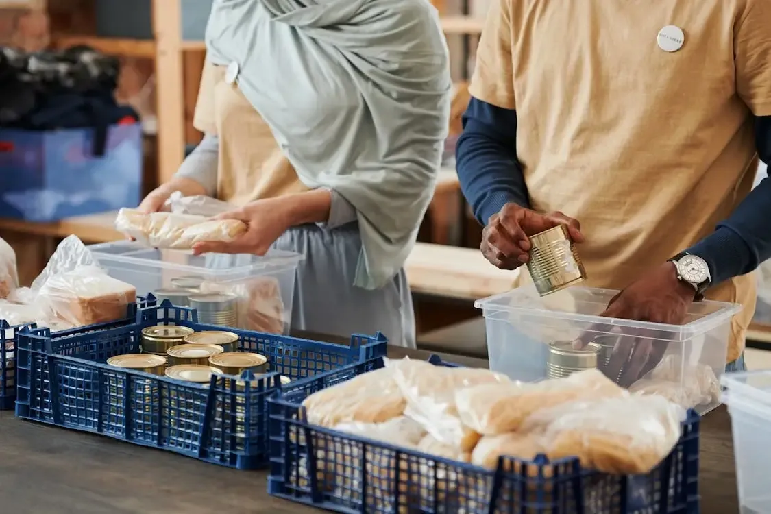 Volunteers loading tubs of food